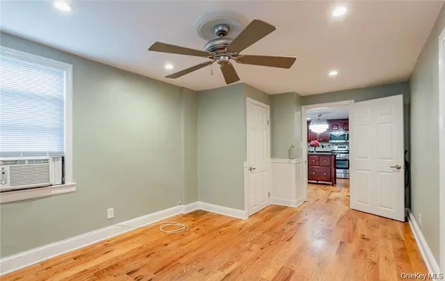 a view of a livingroom with wooden floor and a ceiling fan