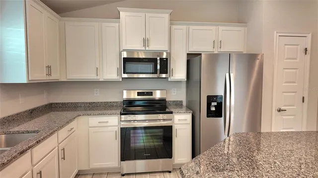 a kitchen with cabinets stainless steel appliances and a counter space