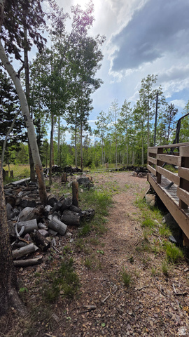 5782 Pineview Loop, Unit 921 Kamas, UT 84036 - Photo 19 of 29 Outdoor space featuring a natural dirt path, a wooden deck, mature trees, and natural landscaping