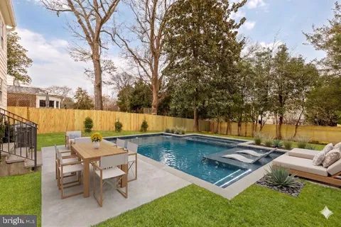 an outdoor sitting area with swimming pool and furniture
