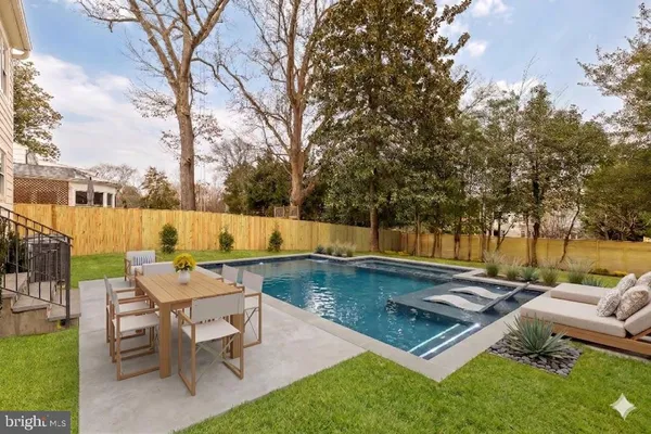 an outdoor sitting area with swimming pool and furniture