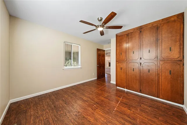 a spacious bathroom with a granite countertop sink a toilet and a mirror