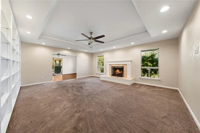 an empty room with wooden floor closet and windows