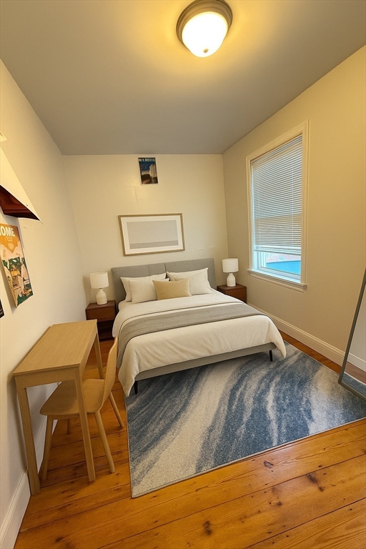 21 Highland Street, Unit 2 Boston, MA 02119 - Photo 7 of 9 a bedroom with a bed and wooden floor