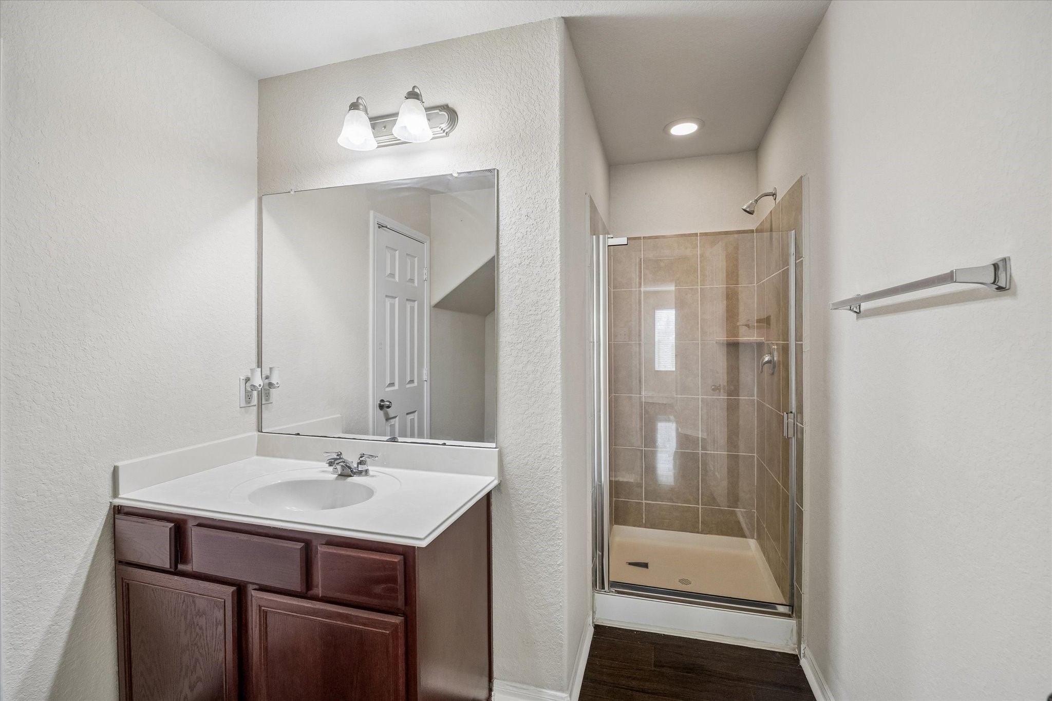 15642 South Fall Fern Circle Houston, TX 77044 - Photo 30 of 32 a bathroom with a sink a mirror and a shower