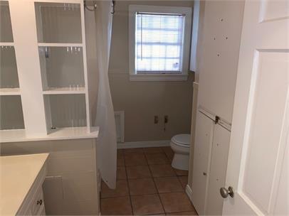 2411 30th Street Lubbock, TX 79411 - Photo 11 of 25 a bathroom with a granite countertop toilet and a shower