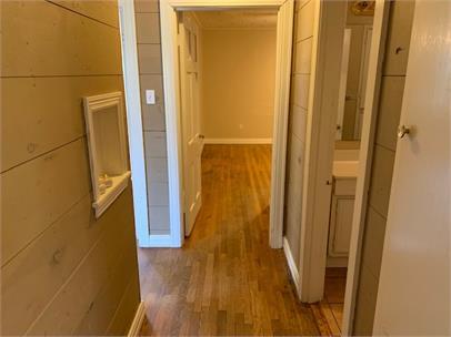2411 30th Street Lubbock, TX 79411 - Photo 12 of 25 a view of a hallway with wooden floor and a bathroom