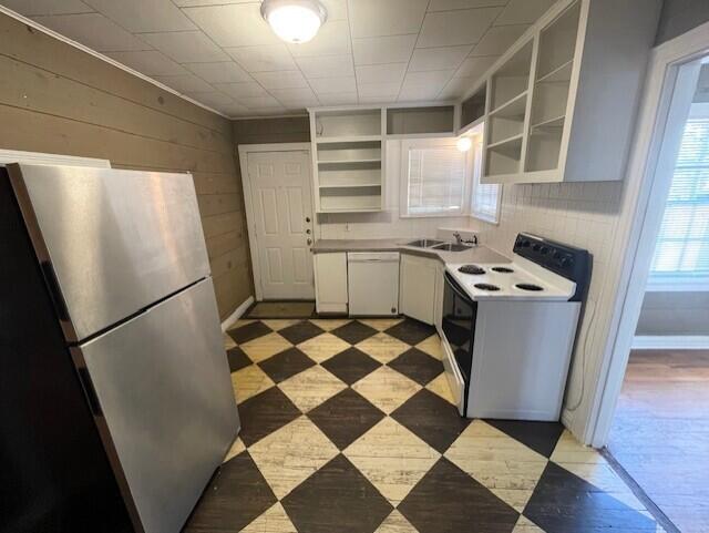 2411 30th Street Lubbock, TX 79411 - Photo 6 of 25 a kitchen with a checkered floor and a refrigerator