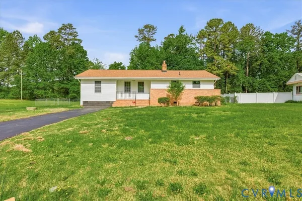 a front view of a house with a yard and trees