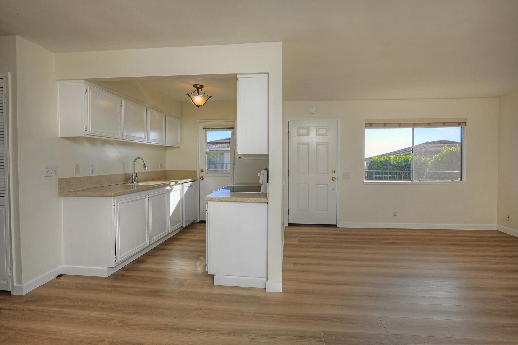 5945 Hickory Street, Unit 4 Carpinteria, CA 93013 - Photo 3 of 19 a kitchen with wooden floors and white cabinets