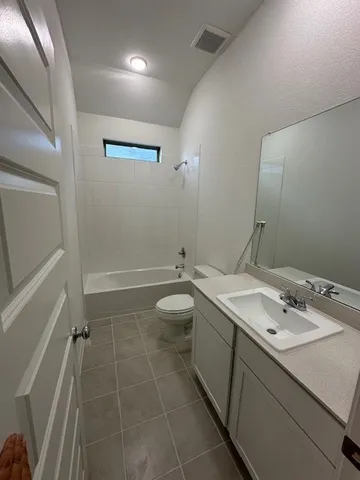 a bathroom with a double vanity sink and mirror with toilet
