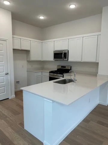 a kitchen with kitchen island a stove a sink and a refrigerator