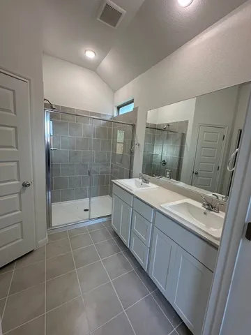 a bathroom with a glass door shower a sink and a mirror