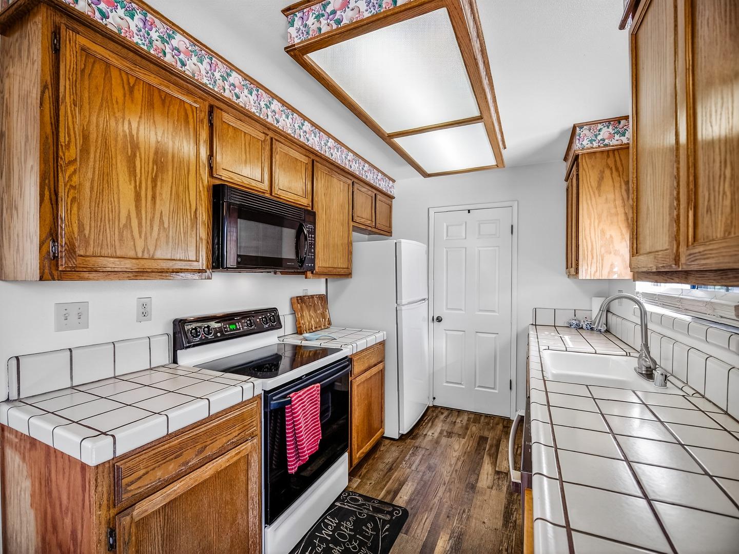 1056 Padre Drive, Unit 8 Salinas, CA 93901 - Photo 21 of 43 a kitchen with stainless steel appliances a stove a sink and a microwave