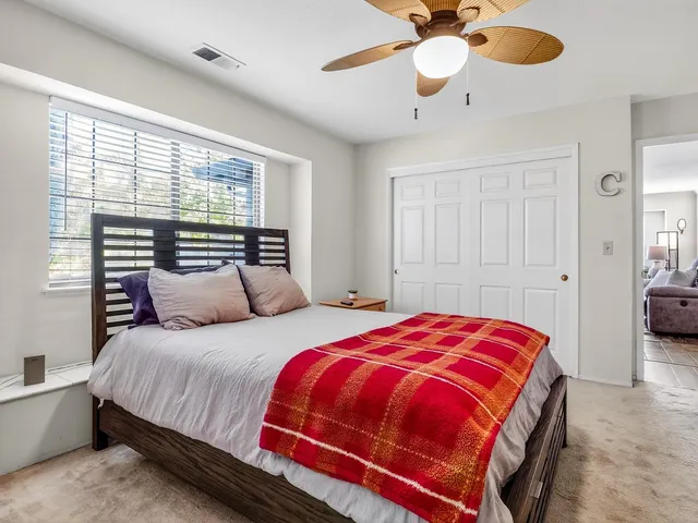 a bedroom with a bed and a ceiling fan