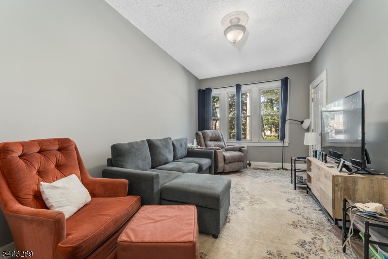 49 Caldwell Place, Unit 5 Springfield, NJ 07081 - Photo 12 of 41 a living room with furniture a large window and a flat screen tv