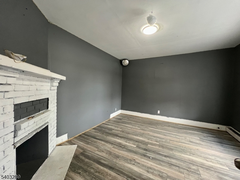 49 Caldwell Place, Unit 5 Springfield, NJ 07081 - Photo 25 of 41 a view of empty room with wooden floor and fireplace