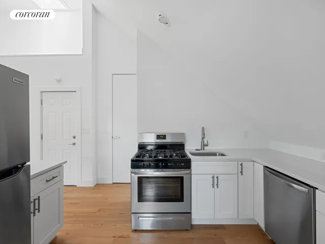 a kitchen with white cabinets and appliances
