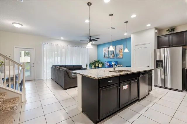 a kitchen with stainless steel appliances granite countertop a stove a refrigerator a sink and a refrigerator