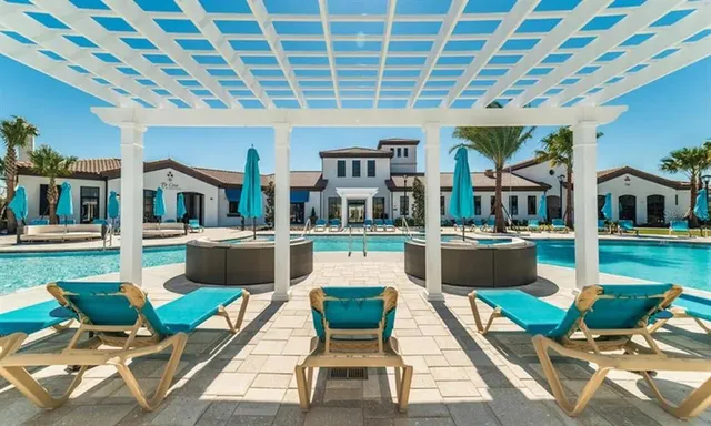 a front view of a house with swimming pool and seating