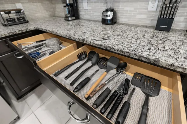 a close view of a sink a stove and storage space