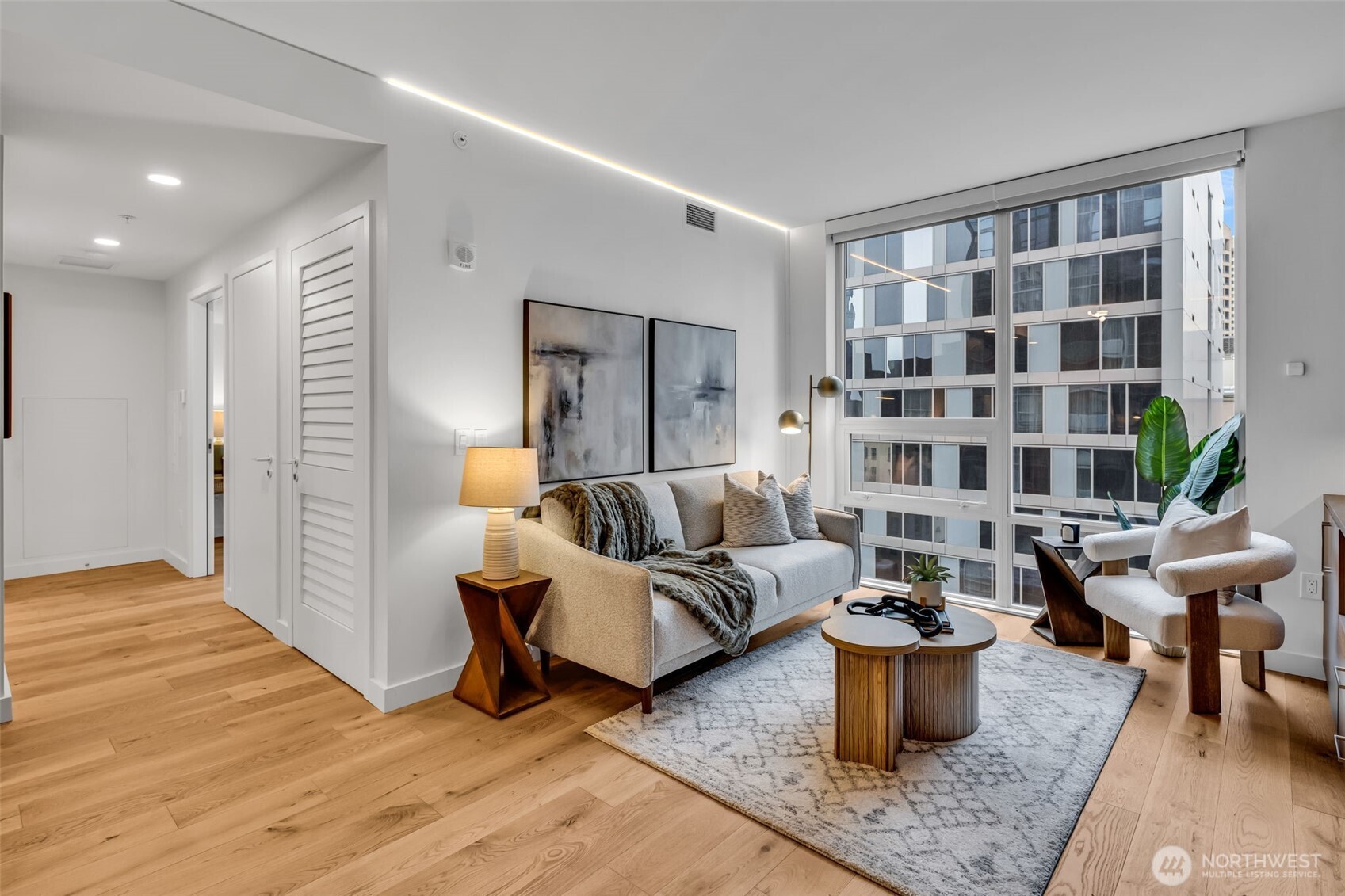 121 Stewart Street, Unit 1003 Seattle, WA 98101 - Photo 20 of 40 a living room with furniture and wooden floor