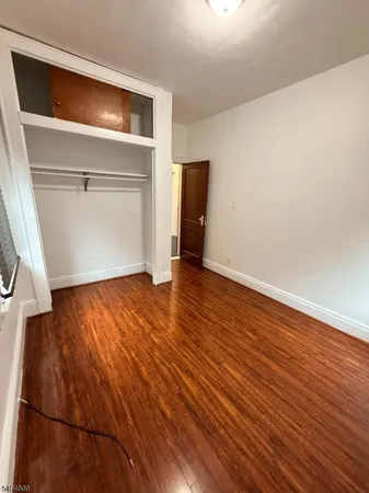 an empty room with wooden floor and closet