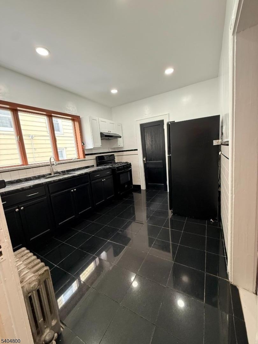 200 North 15th Street, Unit 1 Bloomfield, NJ 07003 - Photo 2 of 13 a kitchen with granite countertop a refrigerator and a stove top oven