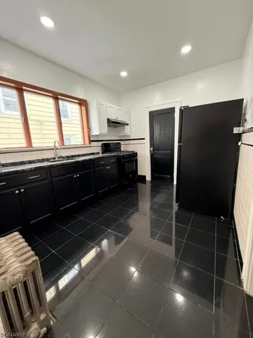 a kitchen with granite countertop stainless steel appliances a sink stove and refrigerator