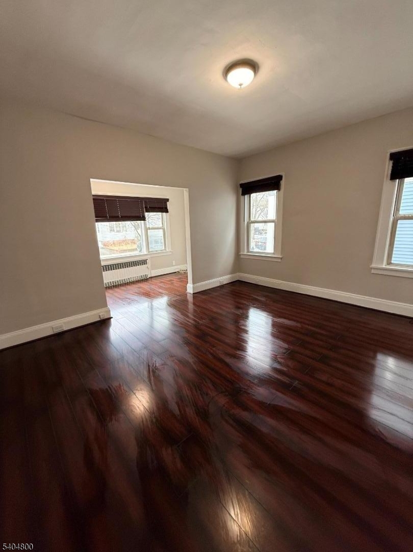 200 North 15th Street, Unit 1 Bloomfield, NJ 07003 - Photo 7 of 13 a view of an empty room with wooden floor and a window