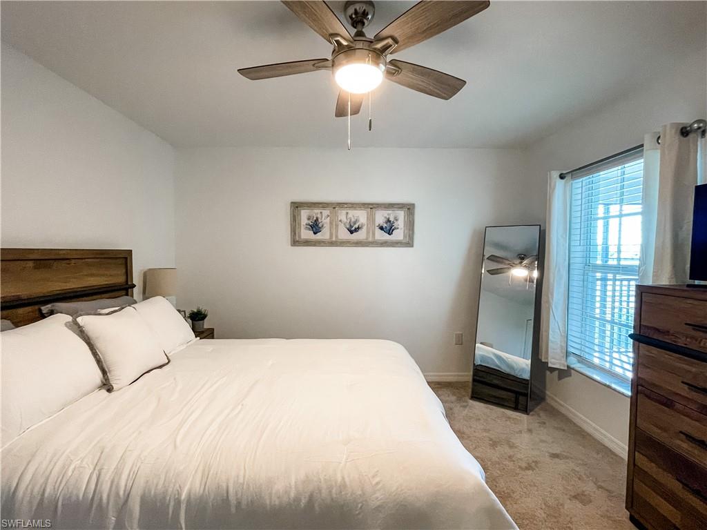 16000 Grassland Lane, Unit 3127 Babcock Ranch, FL 33982 - Photo 23 of 44 a bedroom with a bed and a chandelier
