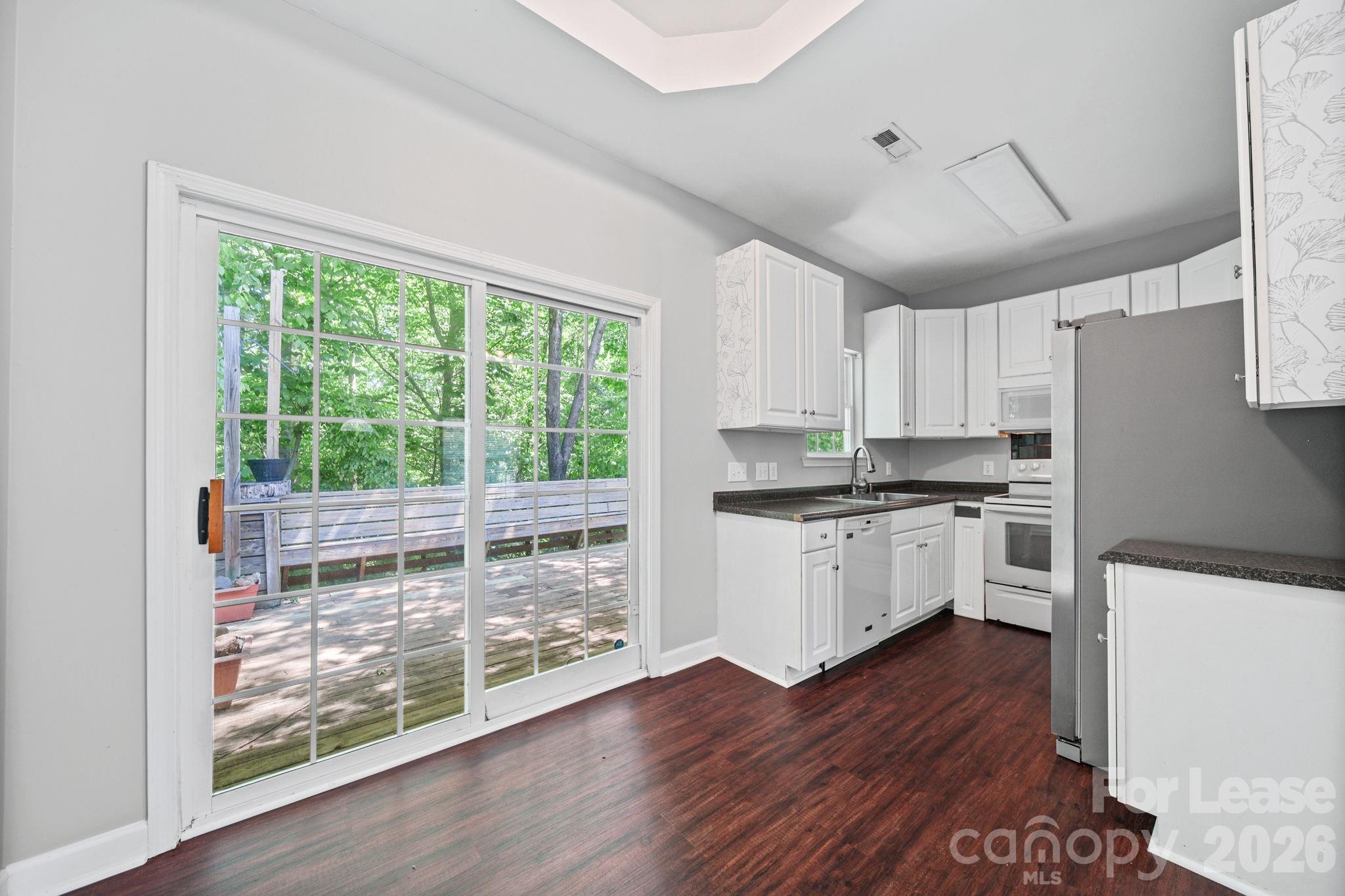 1728 Brian William Road Charlotte, NC 28212 - Photo 5 of 15 a kitchen with wooden floors and white cabinets