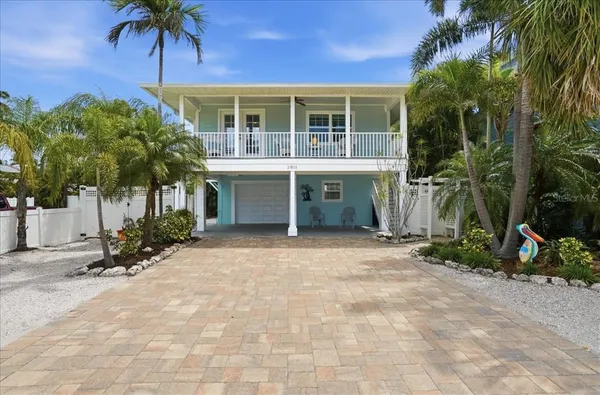 a front view of a house with a yard and potted plants