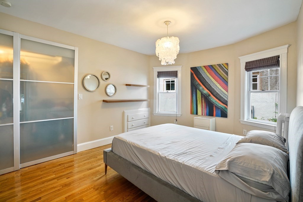23 Stetson Street, Unit ONE Brookline, MA 02446 - Photo 9 of 15 a bedroom with a bed and a chandelier