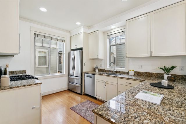 a kitchen with stainless steel appliances granite countertop a stove a sink and a refrigerator