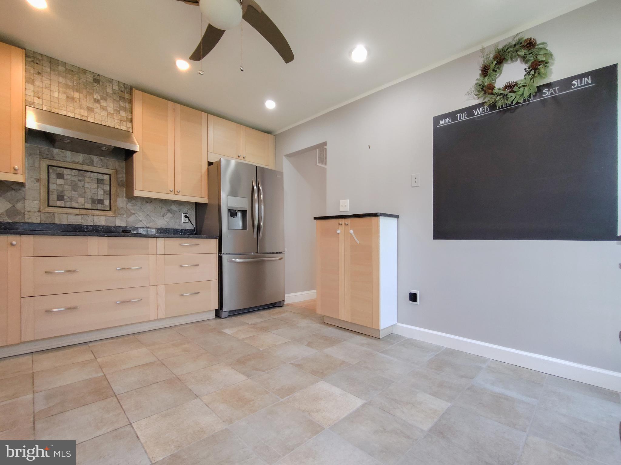9513 Cherry Oak Court Burke, VA 22015 - Photo 12 of 40 a kitchen with granite countertop a refrigerator a sink and white cabinets