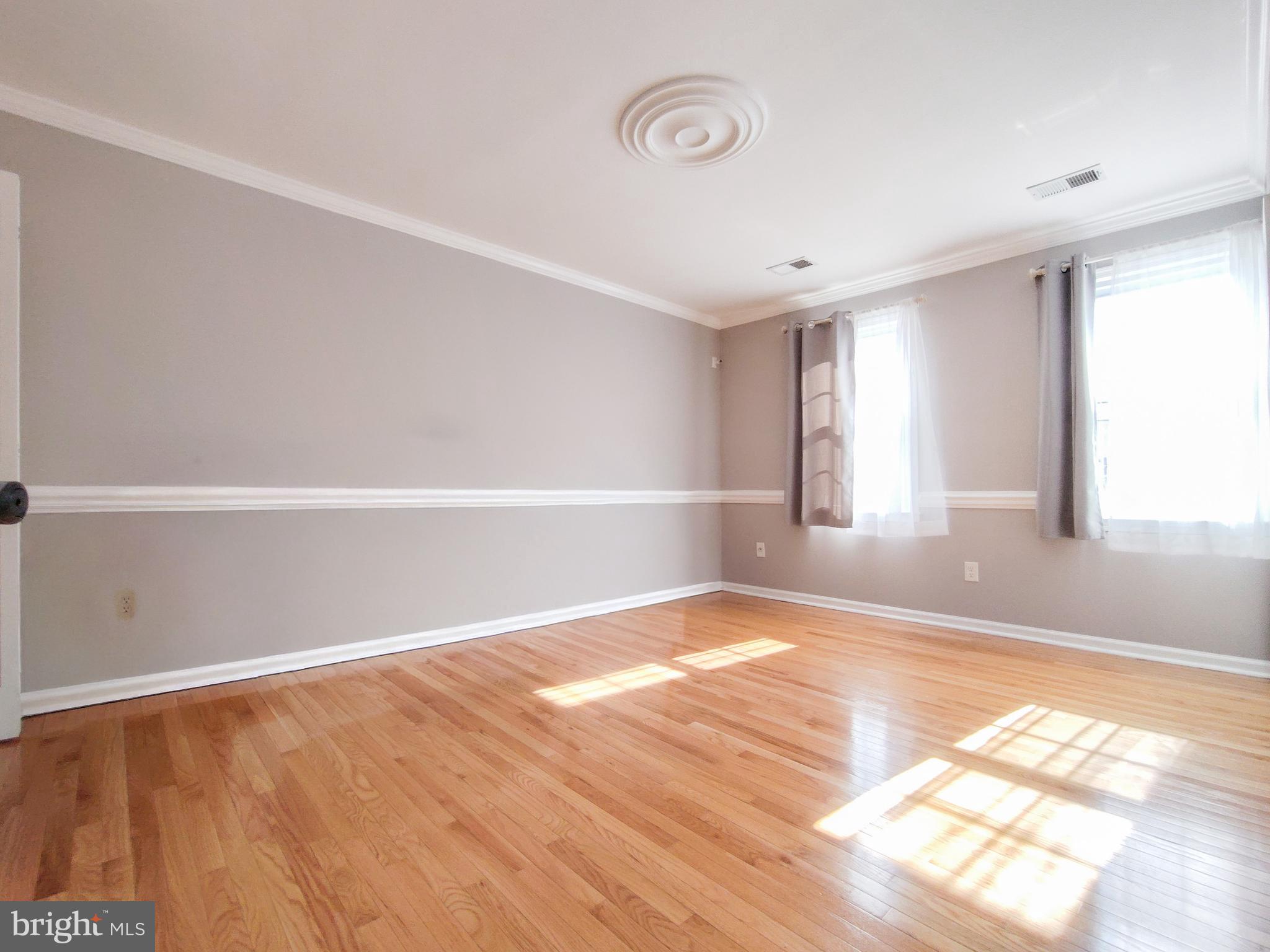 9513 Cherry Oak Court Burke, VA 22015 - Photo 15 of 40 a view of an empty room with wooden floor and a window