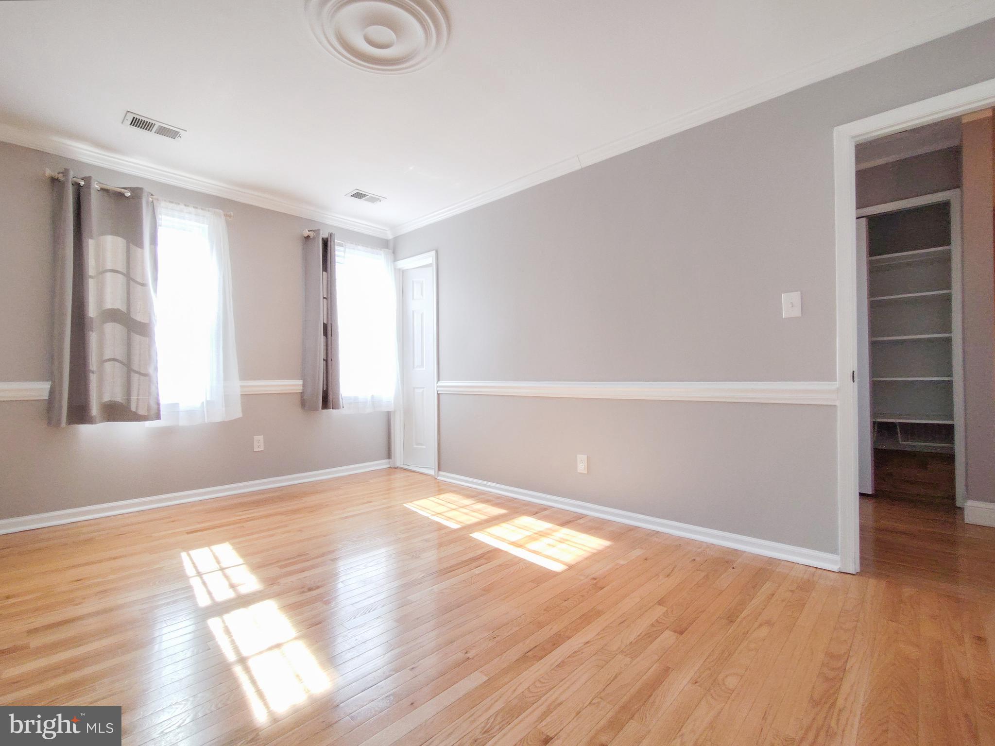 9513 Cherry Oak Court Burke, VA 22015 - Photo 17 of 40 a view of an empty room with wooden floor and closet