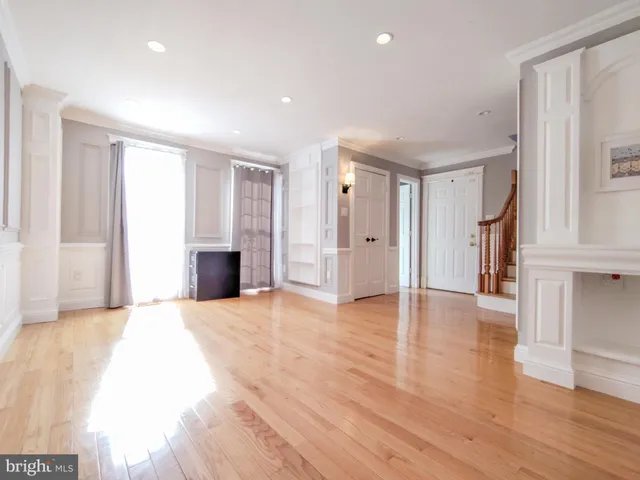 a view of empty room with wooden floor and fireplace