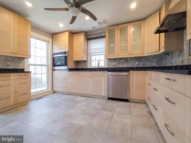 a kitchen with granite countertop a stove sink and cabinets