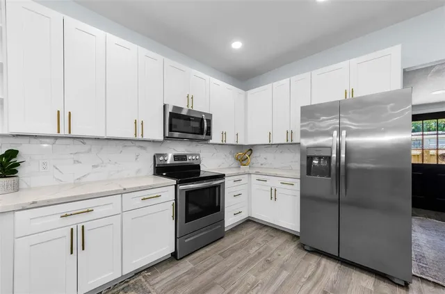 a kitchen with white cabinets stainless steel appliances and sink