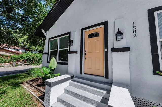 a front view of a house with plants