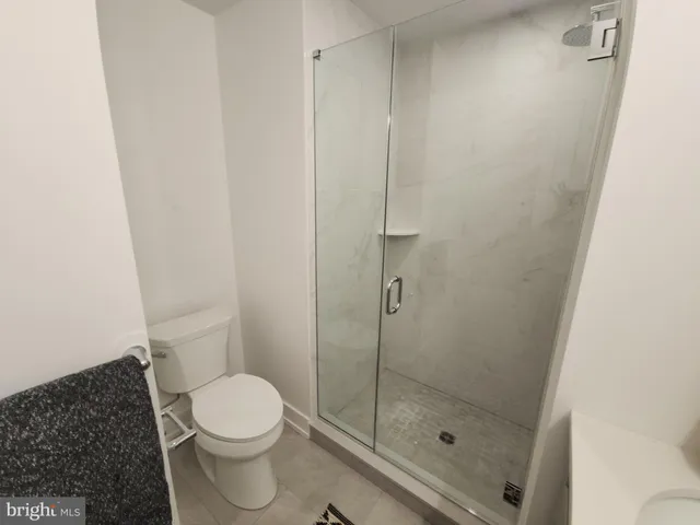 a white toilet sitting next to a shower