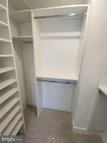 a view of walk in closet with empty racks