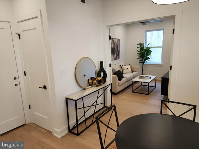 a living room with furniture a window and wooden floor