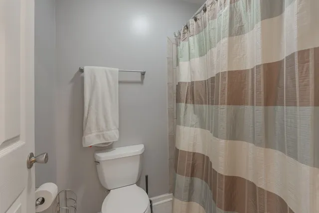a bathroom with a toilet and a shower curtain