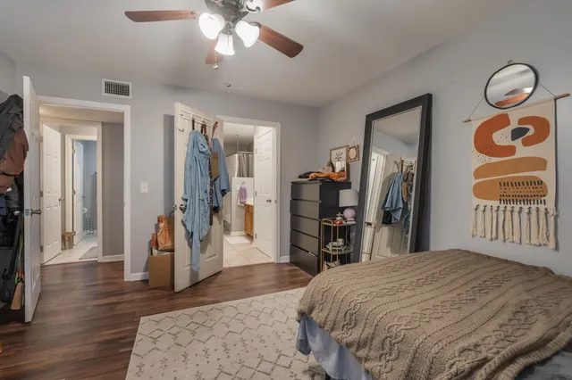a bedroom with a bed and a large mirror on the dresser