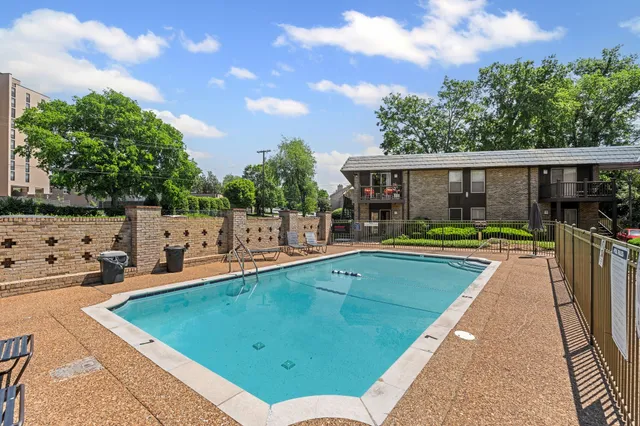 a view of a swimming pool with a patio and a yard