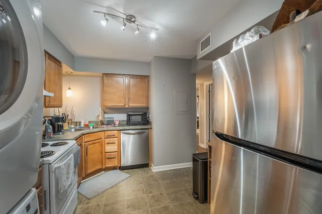 a kitchen with granite countertop a refrigerator and a sink