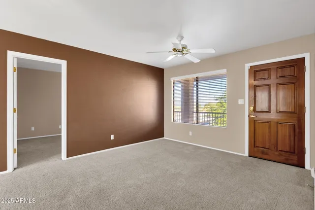a view of empty room with windows and chandelier fan